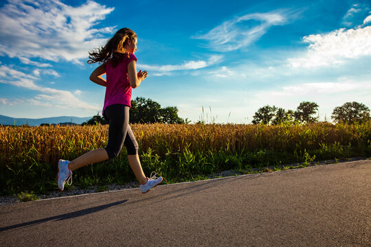 Teenage girl running against blue sky 