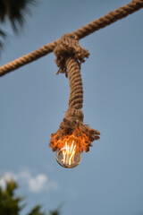 Decorative garden lighting design made with bulbs and thick rope