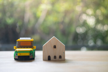 Toy car with miniature house against blur nature background