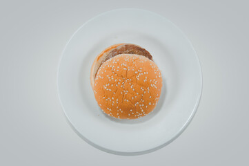 Pork hamburger bun with sesame seeds on white plate