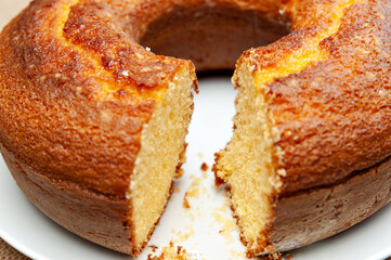 Cornmeal Cake (Bolo de Fuba) cut Brazilian style on a white plate. Isolated on jute. Front view. Close-up.