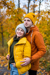 cute beautiful couple in love posing over autumn forest background