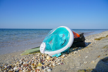 snorkeling mask and fins lie on the seashore