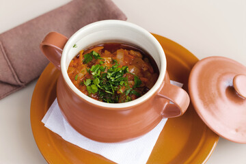 Potatoes with meat in ceramic pot. Morning atmospheric lighting, fashionable trendy spot soft focus. Preparation for design creative menu.