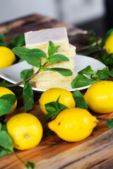 Sliced shortcake, many lemons and mint on wooden table