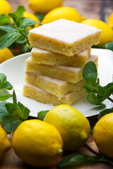 Sliced shortcake, many lemons and mint on wooden table