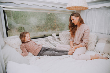 Happy family - mother and little daughter relaxing hugging and having fun in countryside inside...