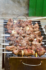 Grilled kebab cooking on metal skewer. Roasted meat cooked at barbecue. BBQ fresh beef meat chop slices. Traditional eastern dish, shish kebab. Grill on charcoal and flame, picnic, street food
