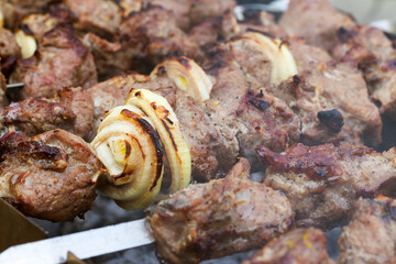 Grilled kebab cooking on metal skewer. Roasted meat cooked at barbecue. BBQ fresh beef meat chop slices. Traditional eastern dish, shish kebab. Grill on charcoal and flame, picnic, street food