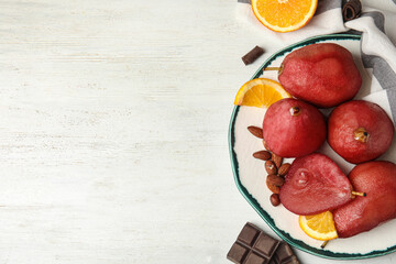 Delicious mulled wine poached pears served on white wooden table, flat lay. Space for text