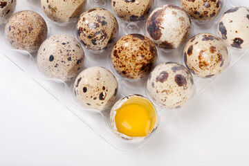 Fototapeta premium Eggs quail, broken egg in plastic container