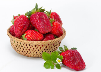 Fresh strawberries in wicker basket close-up on white background
