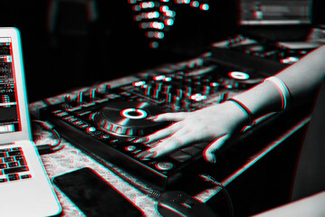 girl DJ mixes music with her hands on a music mixer in a night club