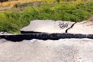 Broken road asphalt cracked and shifted by landslide after earthquake. Landslide caused by torrential rains of Hurricane CHRISTIE.