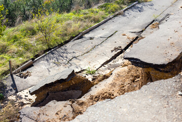 Broken road asphalt cracked and shifted by landslide after earthquake. Landslide caused by torrential rains of Hurricane CHRISTIE.
