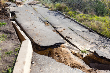 Broken road asphalt cracked and shifted by landslide after earthquake. Landslide caused by torrential rains of Hurricane CHRISTIE.