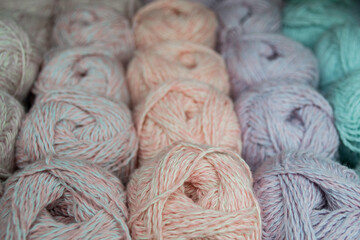 Close-up of skeins of lilac, pink, turquoise thread skeins of pastel colors. Thread background