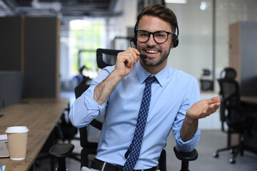 Smiling friendly handsome young male call centre operator.