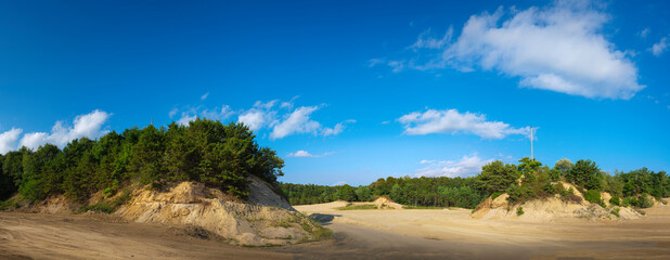 Panoramic cloudscape and landscape of unpaved new roads and open space in the green forest