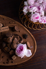  delicious chocolate truffles around ingridients with pink rose bouquet. healthy sweets and present...