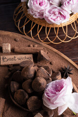  delicious chocolate truffles around ingridients with pink rose bouquet. healthy sweets and present...