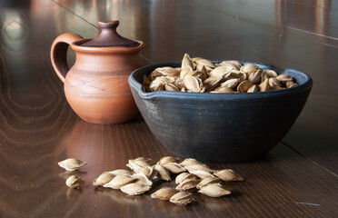 Plum pits in a dark clay plate on a wooden table