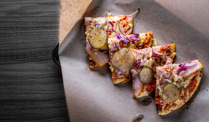 slice of Pizza with Mozzarella cheese, bacon, ham, tomato sauce, pepper, pickled cucumbers