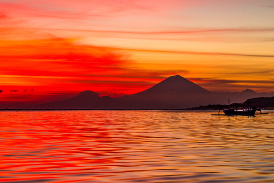 Sunset with volcano silhouetted against the sun
