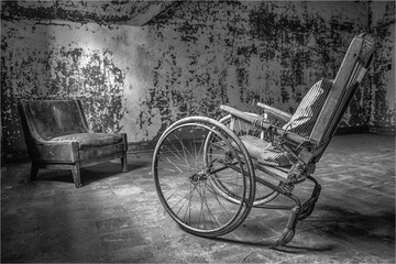 Fototapeta na wymiar Antique wheelchair in an abandoned mental institution, in black and white