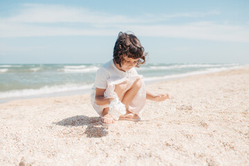 Fototapeta na wymiar Curly young toddler girl with seashell