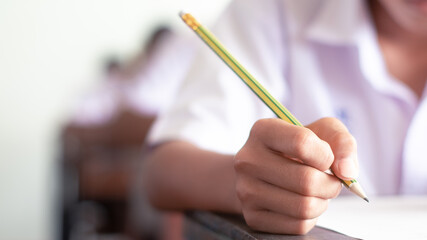 Hand of students writing and taking exam with stress in classroom.16:9 style