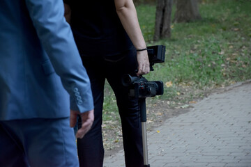 A female hand holds a video camera.