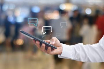 Hand using mobile phone typing, with chat icons. Social media and technology concept.
