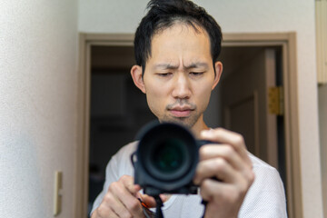 カメラを構えて真剣な表情をする日本人男性