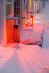 Infrared outdoor heaters in open air on streets of snow-covered city in winter, patio heaters