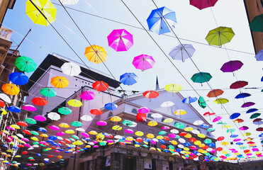 Fototapeta na wymiar Genova, Italy - 0/29/2020: Multicolored umbrellas against the sky, street decorated. LGBT flag. Rainbow love concept. Human rights and tolerance.