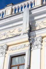 Icicles on drainpipes on the city's buildings in a frosty winter day.
