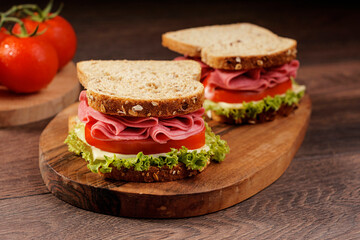 Whole grain bread sandwich with salami, tomato, cheese and fresh lettuce