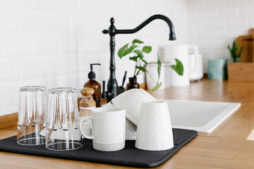 Clean glasses and dishes on towel on the kitchen table after washing © laniko