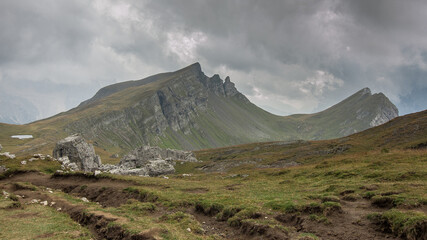 On route to Rifugio Citta di Fiume from Passo Giau over grassy, wild and rocky terrain on stage six of the classic Alta Via 1 trek, Dolomites, Belluno province, South Tyrol, Italy.