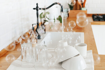 Clean glasses and dishes on towel on the kitchen table after washing