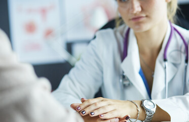 Woman doctor helping senior holding hand in hospital