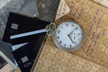 Antique items with bank cards. Pocket watch from the 19th century. Antique trade. Vintage background.