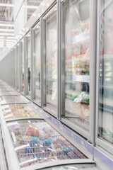 Refrigerated trucks with frozen food in a supermarket. Vertical.
