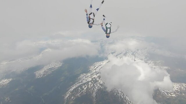 Skydivers over snowy mountains in Norway