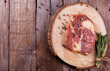 Beef steak with rosemary and pepper on a wooden background