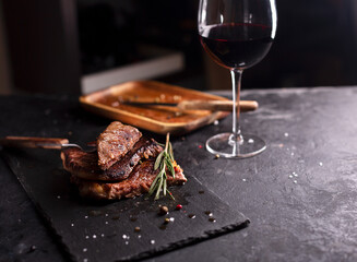 Fototapeta na wymiar Beef Steak on a dark plate with rosemary and pepper