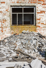 The window of a ruined house with a pile of construction debris