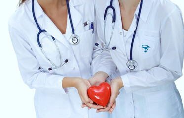 Two woman doctor holding a red heart, isolated on white background