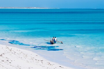 Fototapeta na wymiar African fishermen on their traditional boat on the turquoise sea water of Salary bay in Madagascar